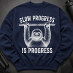 Navy sweatshirt with white text and sloth illustration: "Slow Progress Is Progress".