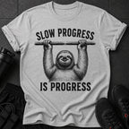 Grey t-shirt with a sloth hanging from a bar and text "SLOW PROGRESS IS PROGRESS".