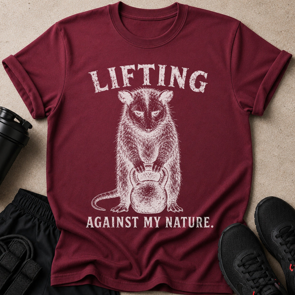 Maroon t-shirt with distressed graphic of a opossum lifting a kettlebell and text.
