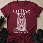 Maroon t-shirt with distressed graphic of a opossum lifting a kettlebell and text.