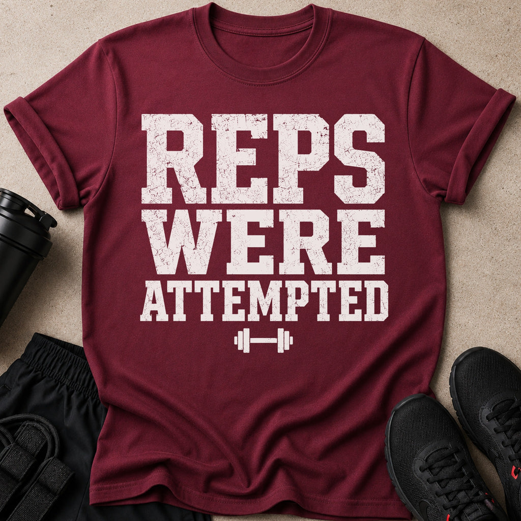 Maroon t-shirt with "REPS WERE ATTEMPTED" text and dumbbell graphic.