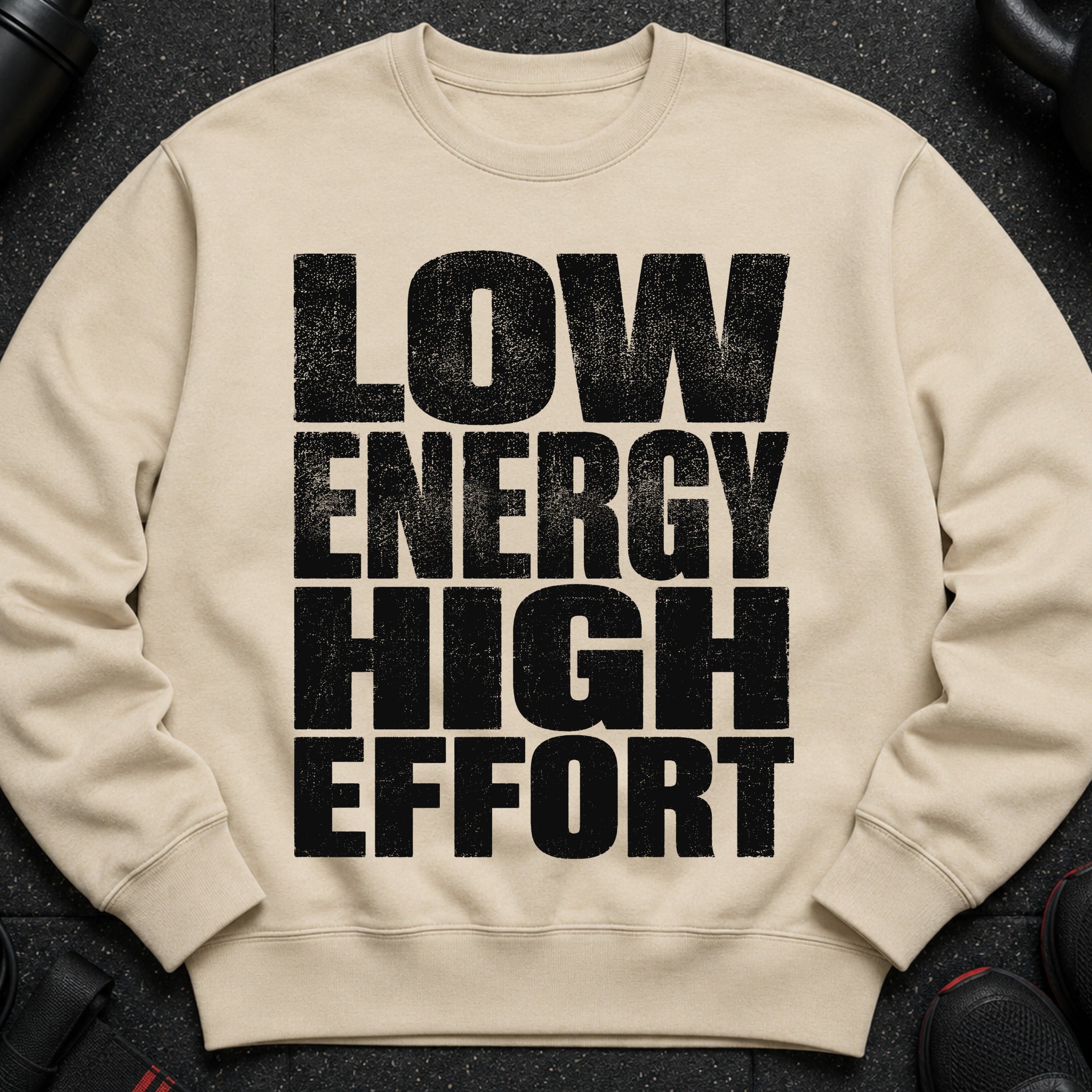 Beige sweatshirt with black distressed text "LOW ENERGY HIGH EFFORT".
