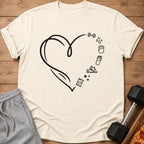 Cream t-shirt with black heart graphic and fitness icons: dumbbell, kettlebell, shaker, sneakers, candy, stars.