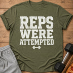 Green t-shirt with white distressed text "REPS WERE ATTEMPTED" and a dumbbell graphic.