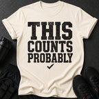 Cream t-shirt with black distressed text "THIS COUNTS PROBABLY" and a checkmark.