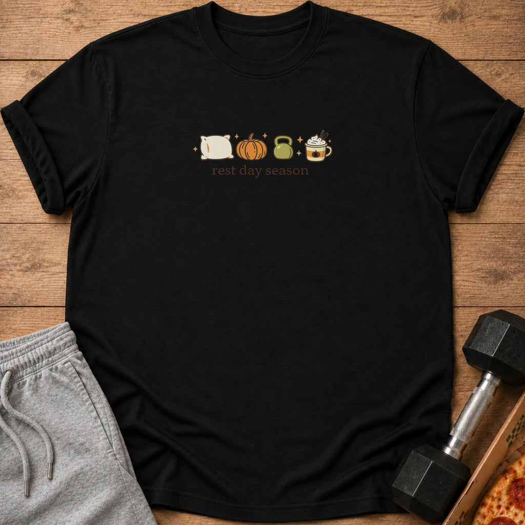 Black t-shirt with pillow, pumpkin, kettlebell, and coffee icons above "rest day season" text.