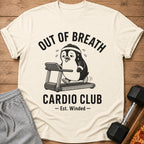 Cream t-shirt with cartoon penguin on treadmill and text "OUT OF BREATH CARDIO CLUB - Est. Winded -".