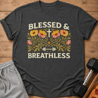 Dark gray t-shirt with "BLESSED & BREATHLESS" text and floral dumbbell graphic.