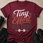 Maroon t-shirt with "Tiny Effort, REAL CREDIT" text and a dumbbell graphic.