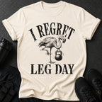 T-shirt with flamingo lifting kettlebell and text "I REGRET LEG DAY".