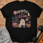 Black t-shirt with "Haunted By Leg Day. Why." ghost graphic, haunted house, pumpkins, and barbell.