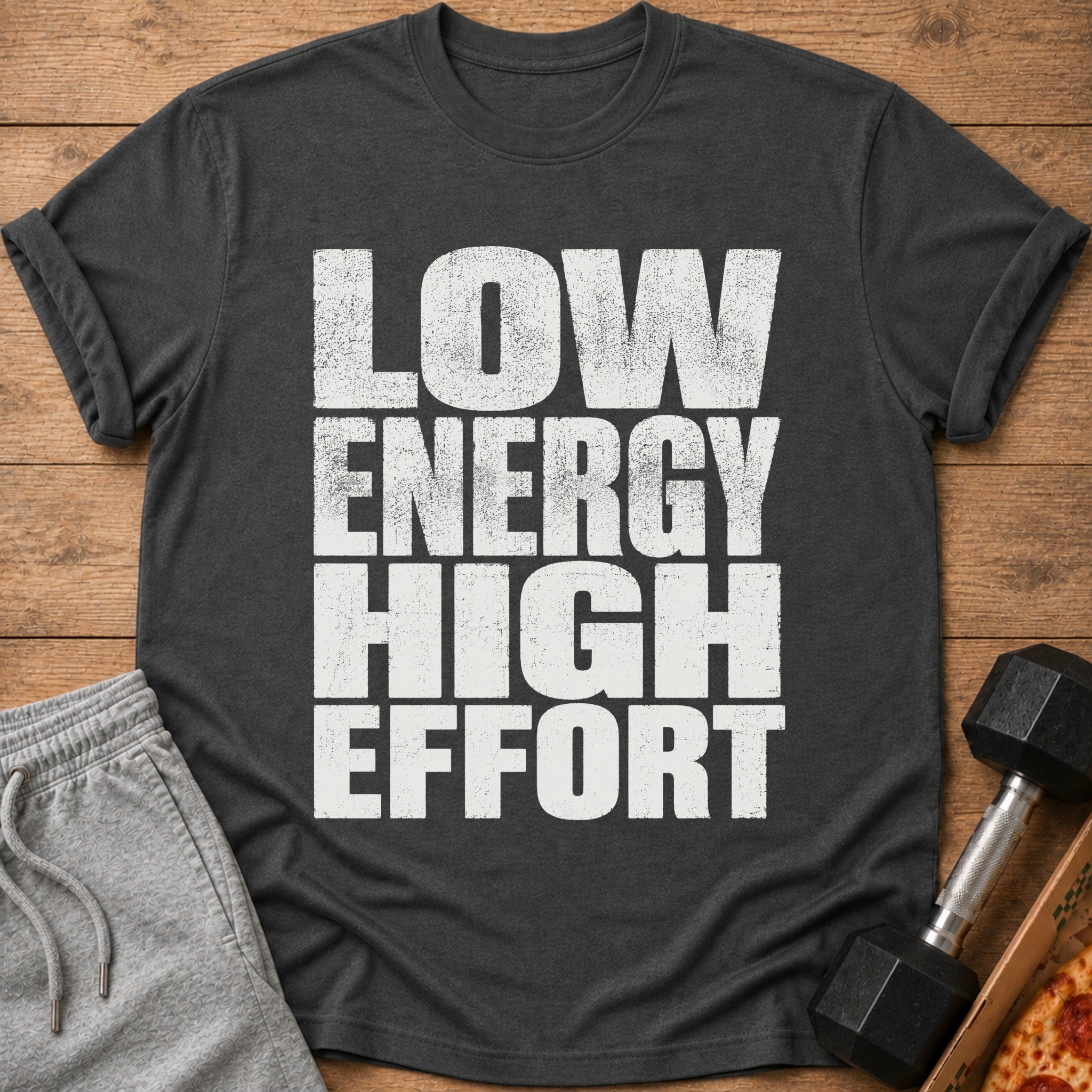 Dark gray t-shirt with "LOW ENERGY HIGH EFFORT" text, gray shorts, dumbbell, and pizza.