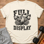 Peacock lifting weights with "FULL DISPLAY" text on a light-colored shirt.