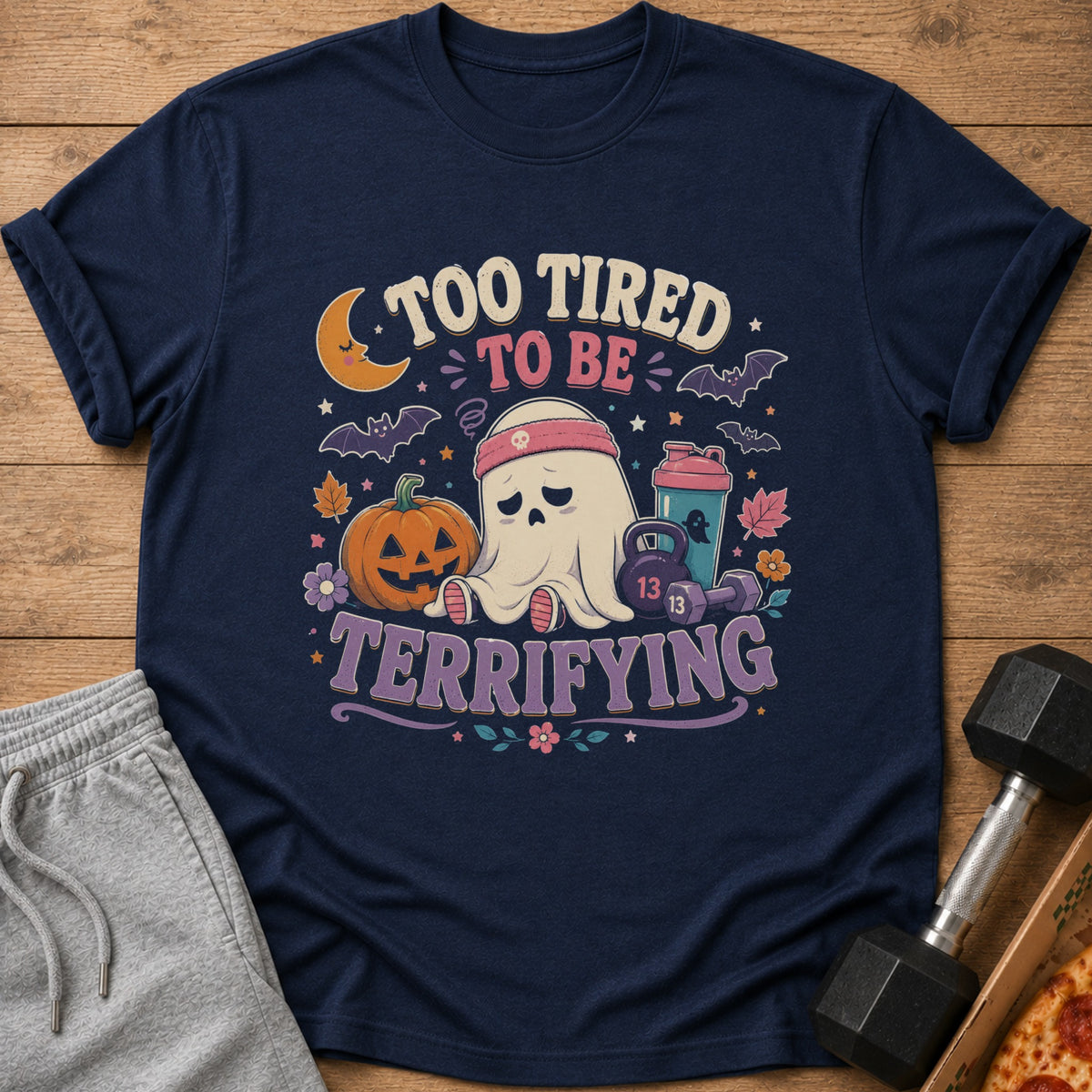 Navy t-shirt with "Too Tired To Be Terrifying" text and a tired ghost, pumpkin, and gym equipment.