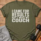 Olive green t-shirt with white text reading "I CAME FOR RESULTS BUT I MISS MY COUCH."