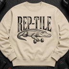Crewneck sweatshirt with black text "REP-TILE" and an alligator holding a dumbbell.