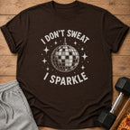 Brown t-shirt with disco ball graphic and text "I DON'T SWEAT I SPARKLE."