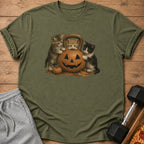 Three kittens surround a jack-o'-lantern kettlebell on a t-shirt.