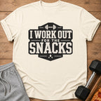 Cream t-shirt with black text "I WORK OUT FOR THE SNACKS" and barbell graphic.