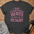 Dark gray t-shirt with pink text that says "Everything Hurts and I'm Hungry."