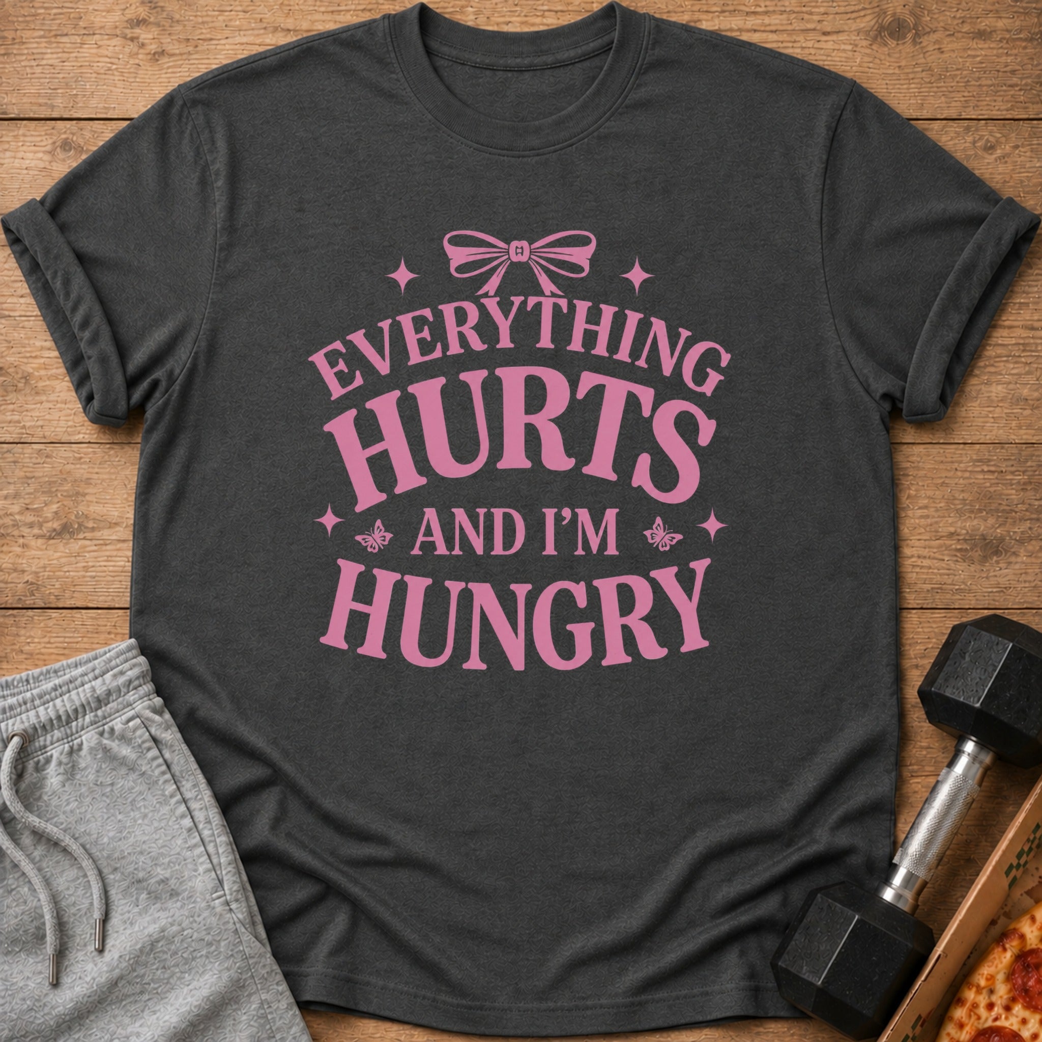 Dark gray t-shirt with pink text that says "Everything Hurts and I'm Hungry."