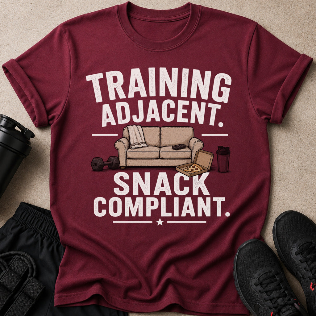 Maroon t-shirt with "TRAINING ADJACENT. SNACK COMPLIANT." text and gym accessories.