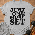 Gray t-shirt with black text "JUST ONE MORE SET" alongside workout gear.