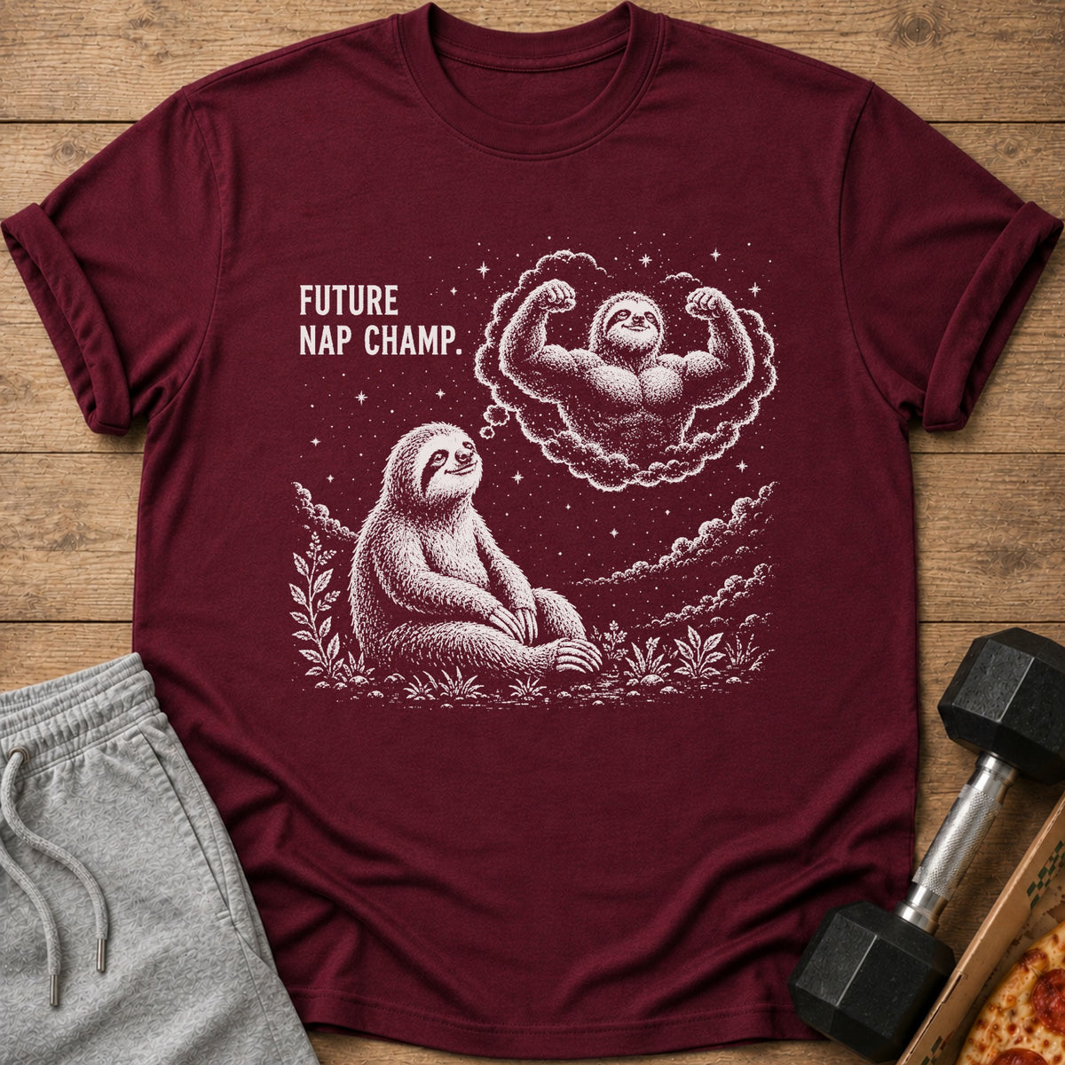 Maroon t-shirt with a sloth dreaming of a muscular sloth, text reads "FUTURE NAP CHAMP."
