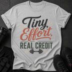 Grey t-shirt with "Tiny Effort, Real Credit" text and barbell graphic.