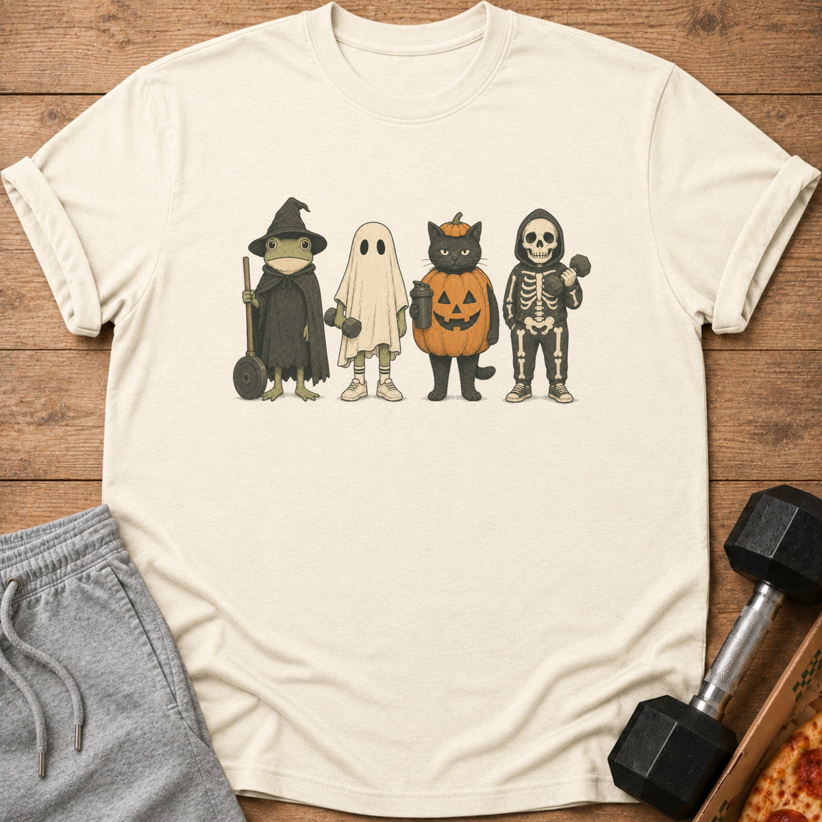 T-shirt with frog, ghost, cat, and skeleton characters in Halloween costumes.