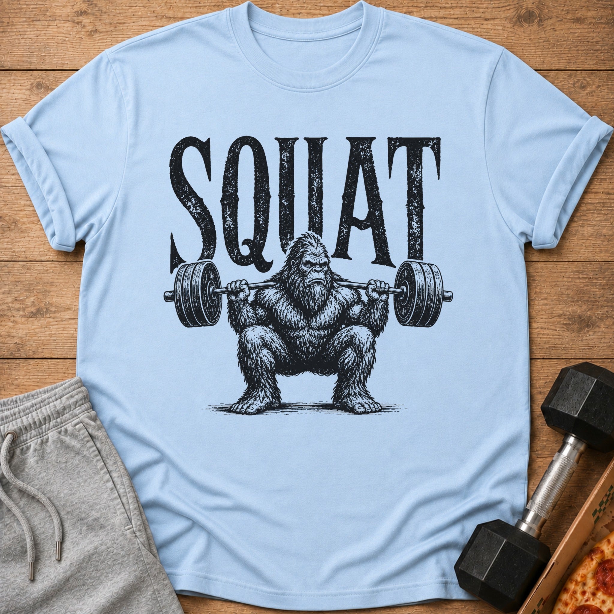 Light blue t-shirt with Bigfoot text art and a weightlifter Bigfoot.