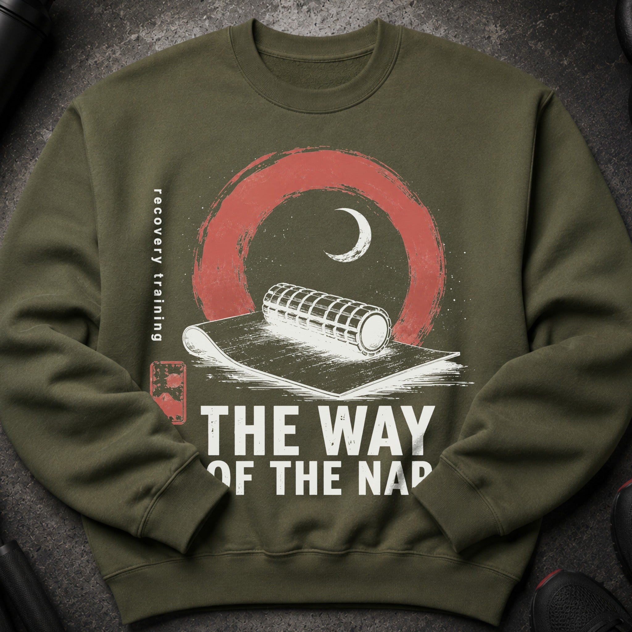 Olive green crewneck sweatshirt with a graphic of a foam roller and moon, text reads "Recovery Training The Way of the Nap".