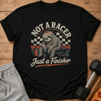 Black t-shirt graphic with sloth sitting on bench, text "NOT A RACER Just a Finisher".