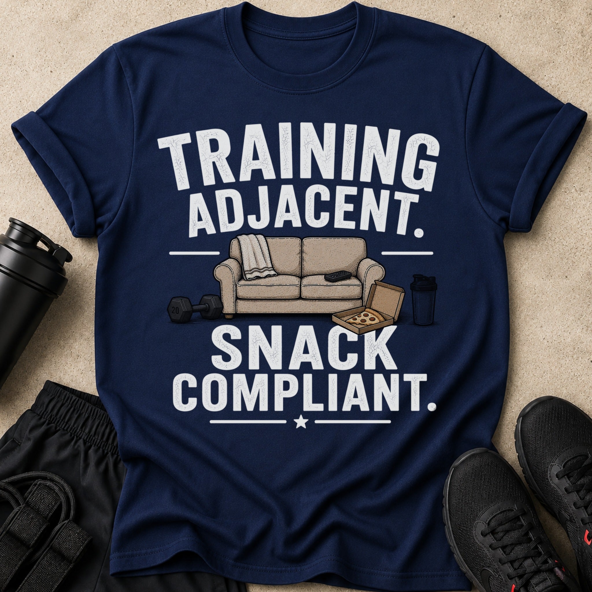 Navy t-shirt with white text "TRAINING ADJACENT. SNACK COMPLIANT." and graphic.
