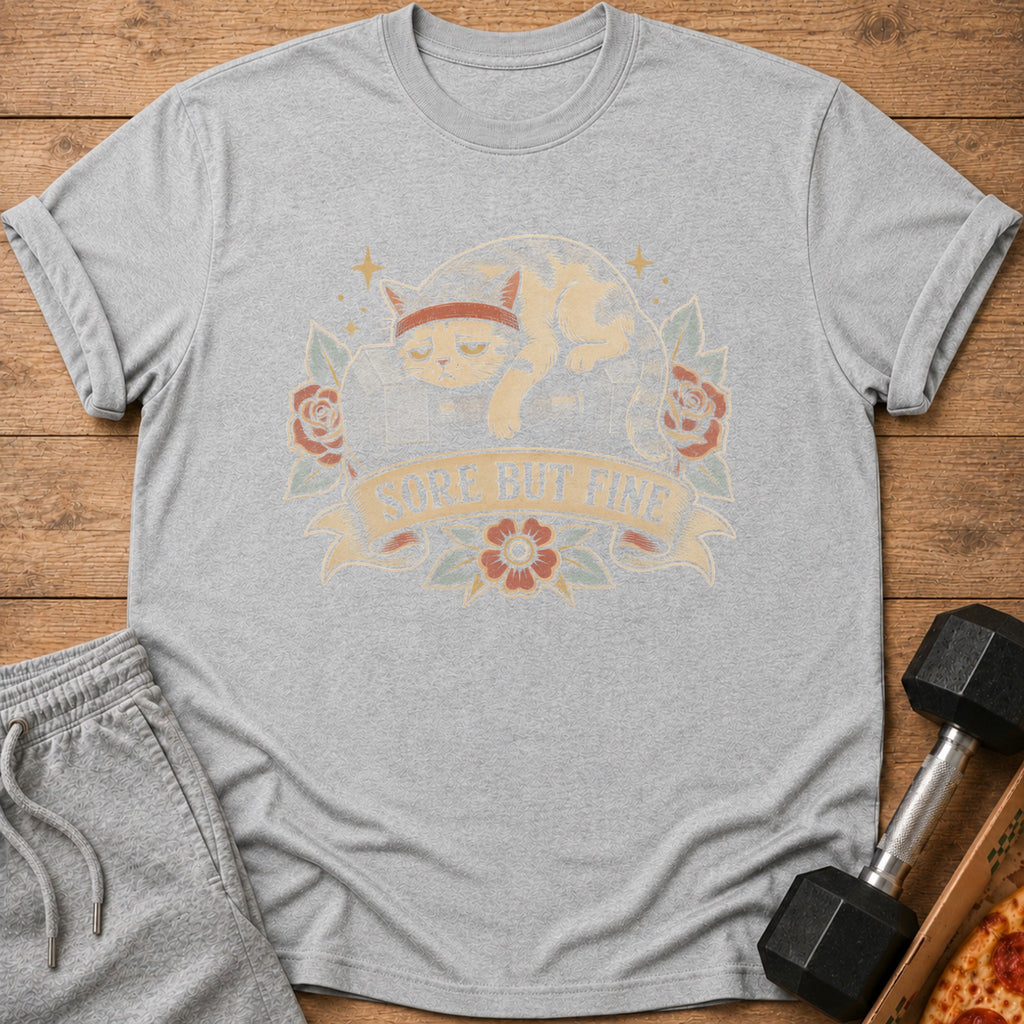 Grey t-shirt with graphic of a cat wearing a headband and text "SORE BUT FINE".