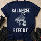 Navy t-shirt with "BALANCED EFFORT." text and a flamingo holding a kettlebell.
